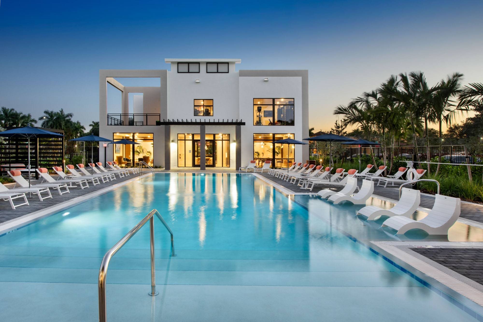 a swimming pool in front of a house with a pool